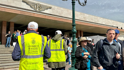 Venice municipal workers in reflective vests outside of the Venezia Santa Lucia train station to assist visitors with a new entrance fee that day-trippers must pay.