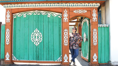 A traveler stands in a colorful doorway in Ulaanbaatar, the capital city of Mongolia, where the adventure travel company is launching a new rail itinerary in 2025.