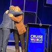 Chad Martin, Israel MInistry of Tourism's director of the U.S. Northeast region, hugged Northstar Travel Group executive vice president Mary Pat Sullivan on the CruiseWorld stage.