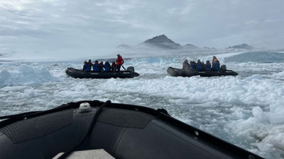 Guests head out on a Zodiac excursion off the coast of Greenland.