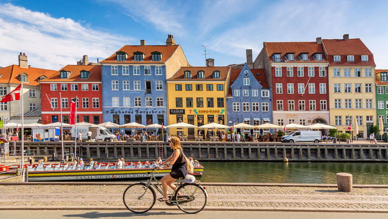 A sightseeing boat sails along Copenhagen's colorful Nyhavn waterfront.