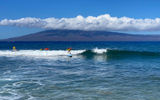 Surfers at Kaanapali Surf School in Maui hit the waves in July with the island of Molokai serving as the backdrop.