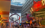 The Utopia of the Seas' Boardwalk neighborhood with a carousel, giant parrot and the Ultimate Abyss slides.