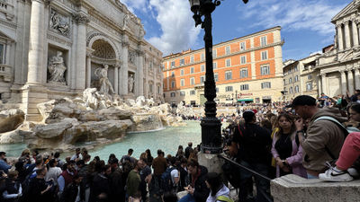 Hotel demand is very high in Italy. Pictured, a crowd around the Trevi Fountain in Rome.